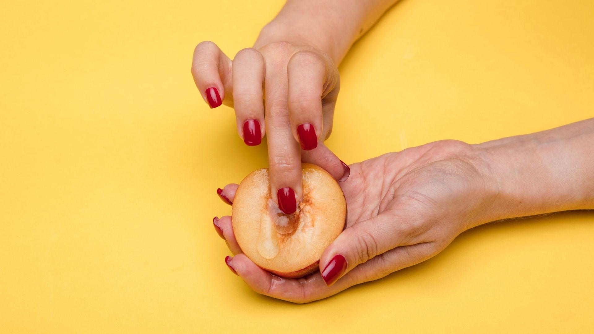 Femme mimant la masturbation sur un fruit